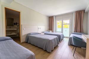 a hotel room with two beds and a window at Hotel Canada Palace in Calafell +39 photos