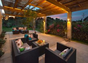 eine Außenterrasse mit Sofas und einer Pergola in der Unterkunft La Casa en el Pinar by Vintage Travel in Biniancolla