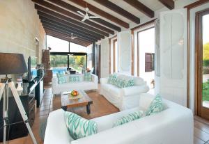 ein Wohnzimmer mit weißen Sofas und einem Tisch in der Unterkunft La Casa en el Pinar by Vintage Travel in Biniancolla
