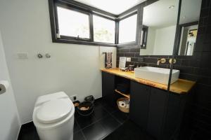 a bathroom with a white toilet and a sink at Serene Mountain Retreat in Jindabyne - Private Tiny Home in Jindabyne