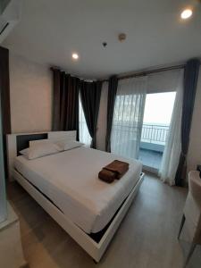 Un dormitorio con una gran cama blanca y grandes ventanales. en Premium 3bedroom120sqm 15floor วิวทะเล frontbeach seaview, en Jomtien Beach 60 fotos más