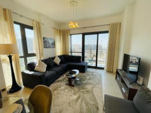 Nadd ShubayḩにあるTown Square Zahra 2B - 2 Bedroom Apartment - Allsopp & Allsoppのソファとテレビのあるリビングルーム