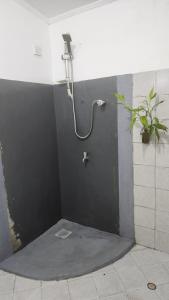 a shower in a bathroom with a black wall at Sapphire Homestay in Dehiwala
