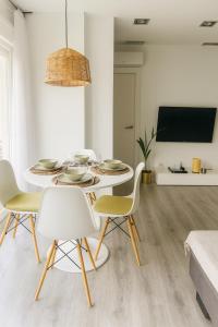 a white dining room with a table and chairs at Apartamento Sol Terraza in Montgat +26 photos