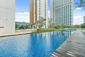a swimming pool in a city with tall buildings at Oswin by Kozystay - Cilandak in Jakarta