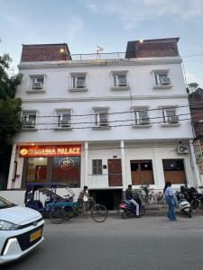 a white building with people standing in front of it at Sunaina Palace in Varanasi
