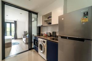 a kitchen with a refrigerator and a washer and dryer at 1BR Designer Mountain View Condo - Central Phuket in Phuket Town