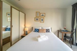 a bedroom with a large white bed with towels on it at 1BR Designer Mountain View Condo - Central Phuket in Phuket Town +37 photos