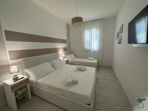 a bedroom with two beds with towels on them at Hotiday Porto Cesareo in Porto Cesareo