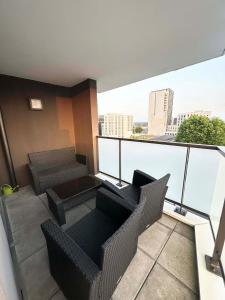 a balcony with two chairs and a couch on a building at Balcon sur docks - 4 lits - 4 beds in Le Havre