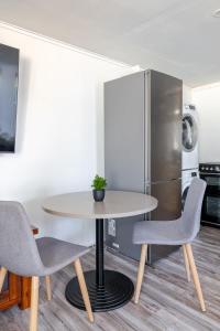 a table and chairs in a kitchen with a refrigerator at Enjoy your home away from home in Rooty Hill