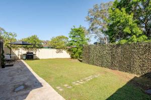 a backyard with a fence and a grass yard at Enjoy your home away from home in Rooty Hill