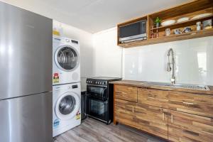 a kitchen with a refrigerator and a washer and dryer at Enjoy your home away from home in Rooty Hill +14 photos