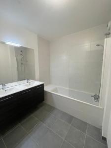 a bathroom with a tub and a sink and a mirror at Balcon sur docks - 4 lits - 4 beds in Le Havre
