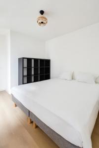 a white bedroom with a large white bed at Balcon sur docks - 4 lits - 4 beds in Le Havre