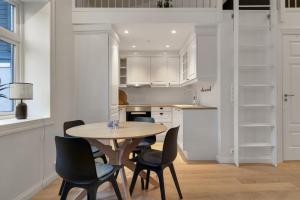 a kitchen with a table and chairs in a room at Northstay - Town Square in Tromsø