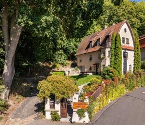 a house with a garden in front of a road at Pension Family in Karlovy Vary