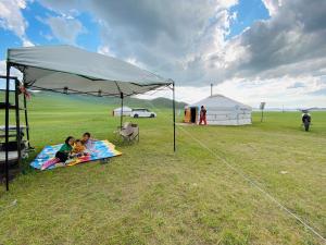two children sitting on a blanket under a tent at Yurt and Mongolian Ger in Arhust