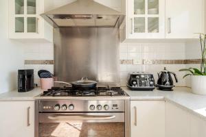 a kitchen with a stove with a pan on it at Beautiful and Colourful House with Parking in Rooty Hill