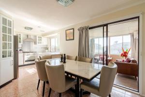 a kitchen and dining room with a table and chairs at Beautiful and Colourful House with Parking in Rooty Hill