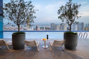 une terrasse sur le toit avec des chaises, une table et des arbres dans l'établissement 22 Macalisterz George Town By Mana-Mana, à George Town