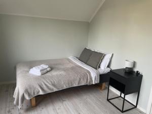 ピーテオにあるGuestly Homes - 3BR Homely Villa in Piteåの白いベッドルーム(ベッド1台、ナイトスタンド付)