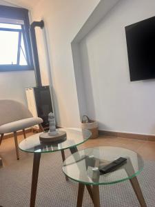 un soggiorno con tavolo in vetro e TV di Finisterre Aloha a Fisterra (Finisterre)