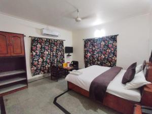 En eller flere senge i et værelse på Hotel Atithi Mount Abu