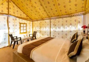 a bedroom with a bed and a table and chairs at desert sweet resort Jaisalmer in Jaisalmer