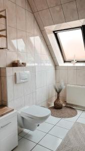 a white bathroom with a toilet and a window at Modern wohnen, nahe Steinhuder Meer in Hagenburg