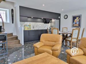 un salon avec des chaises et une table et une cuisine dans l'établissement Gîte Le 47, 6 à 8 personnes, à Louverné