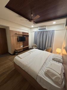 a bedroom with a large bed and a flat screen tv at Reva suites in Arsikere +13 photos