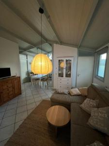 een woonkamer met een bank en een tafel bij Bungalow Het Grootslag in Andijk