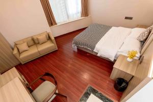 a bedroom with a bed and a chair and a table at Guangzhou Xingke Apartment in Guangzhou