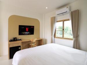 een slaapkamer met een wit bed en een raam bij เดอะริม รีสอร์ท The Rim Resort in Ban Muang +8 foto's
