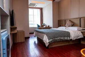 a hotel room with a bed and a television at Guangzhou Xingke Apartment in Guangzhou