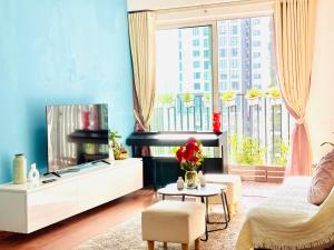 a living room with a tv and a large window at TPHomes Vista Verde in Ho Chi Minh City