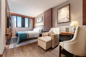 a hotel room with a bed and a desk and chair at Chongqing Meichen Hotel Auto Expo Branch in Chongqing