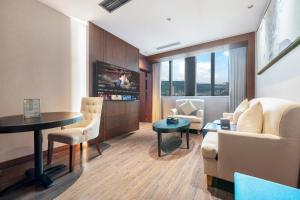 a living room with a couch and a table at Chongqing Meichen Hotel Auto Expo Branch in Chongqing