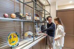 a man and a woman looking at a display case at HOTEL MYSTAYS Kanazawa Katamachi in Kanazawa