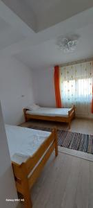a bedroom with two beds and a window at Craii Neamtului in Almaş