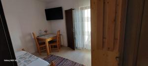 a room with a table and a chair and a table and a door at Craii Neamtului in Almaş +17 photos