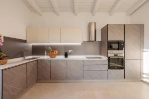 a kitchen with stainless steel appliances and white cabinets at Villa Chloé in Bordighera +76 photos