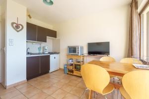 a kitchen and dining room with a table and chairs at Le Cocon du Chaud Costet - Avec balcon in Le Tholy
