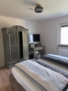 two beds in a room with a tv and a desk at Unger's Ferienwohnung in Isny im Allgäu +11 photos
