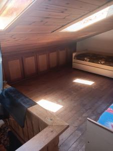 an attic room with two beds and a wooden floor at Appartamento Valle di Cadore in Valle di Cadore