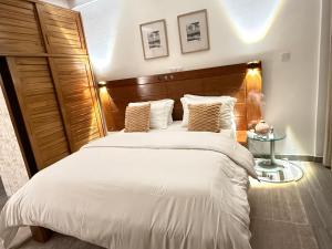 杜阿拉Julianah appart的卧室里有一张带木质床头板的大床