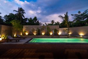 une piscine dans un jardin la nuit dans l'établissement Dhyana Beach Villa, à Ambalangoda