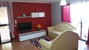 een woonkamer met 2 stoelen en een flatscreen-tv bij Holiday Home Villa Relax in Palermo