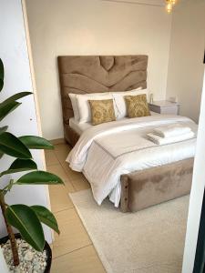 a bedroom with a large bed with gold pillows at Valentine's Suite in Nairobi